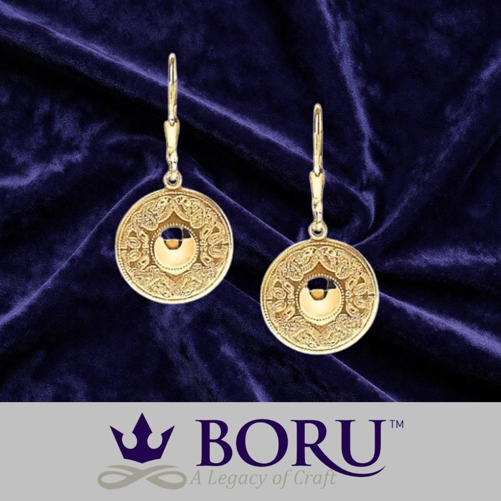 Gold earrings on a purple velvet background with Boru logo.