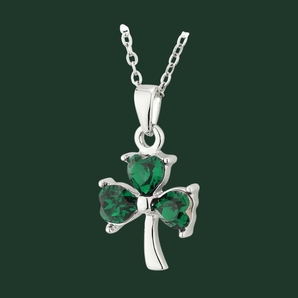 Silver necklace with a green shamrock pendant on a dark green background